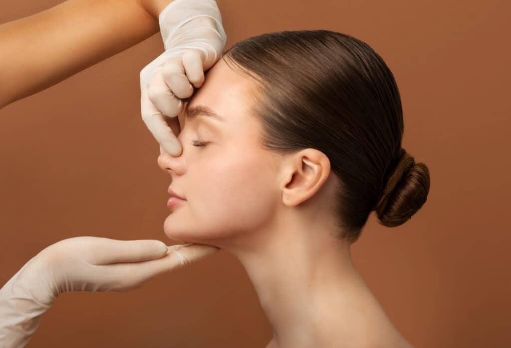 Side profile of a woman having rhinoplasty consultation with her facial plastic surgeon.